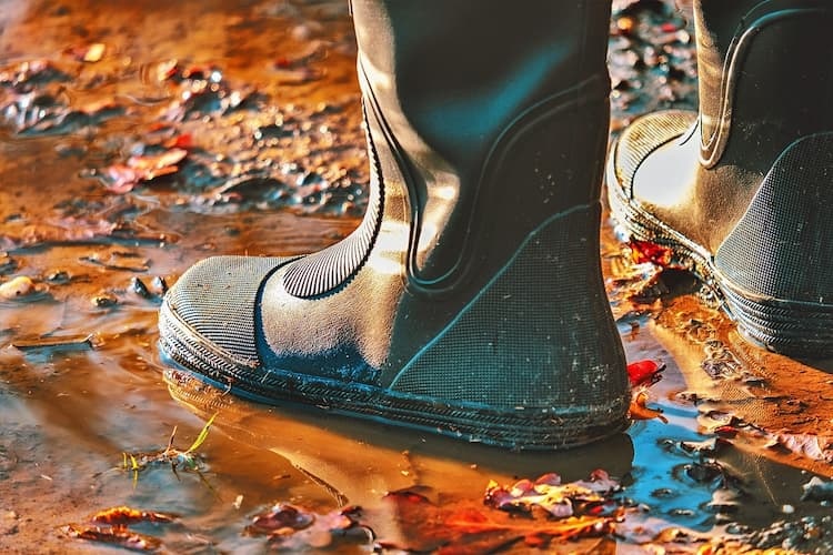 Schutz vor Hochwasser Bild zeigt Gummistiefel im Matsch