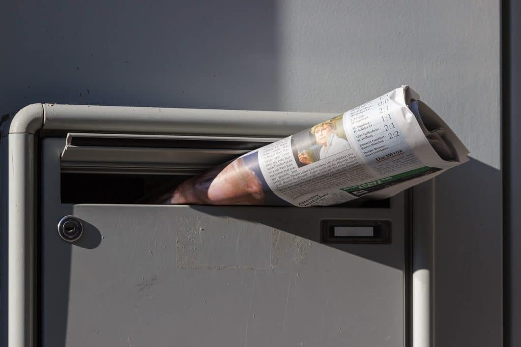 Anspruch auf Briefkasten - informatives für Mieter und Vermieter: Bild zeigt Zeitung, die in Briefkastenschlitz steckt